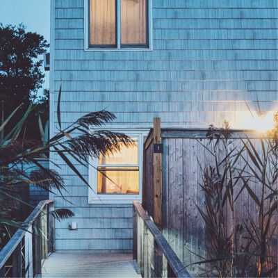 Beach house with lights on inside at twilight